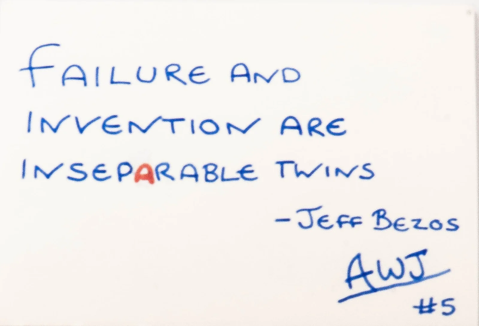 Handwritten in blue ink: Failure and invention are inseparable twins. Attributed to Jeff Bezos. Signed AWJ, number 5.