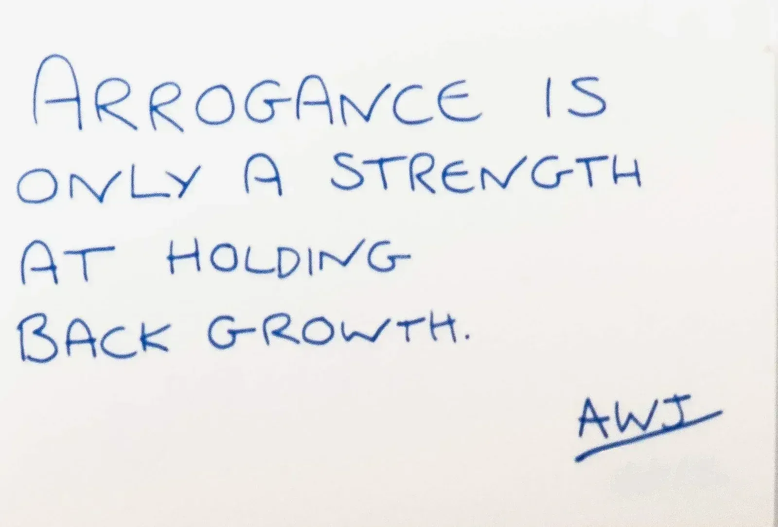 Handwritten in blue ink: Arrogance is only a strength at holding back growth. Signed AWJ, number 13.
