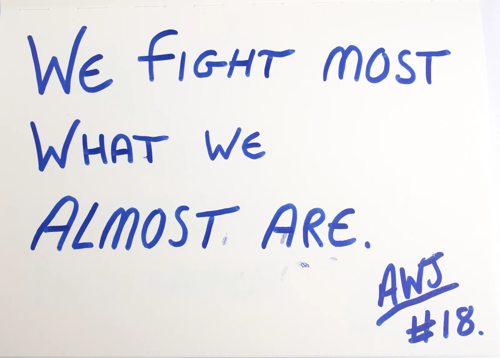 Handwritten in blue ink: We fight most what we almost are. Signed AWJ, number 18.